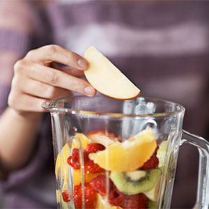 placing fruit into blender