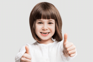 Young girl smiling and giving a thumbs up gesture