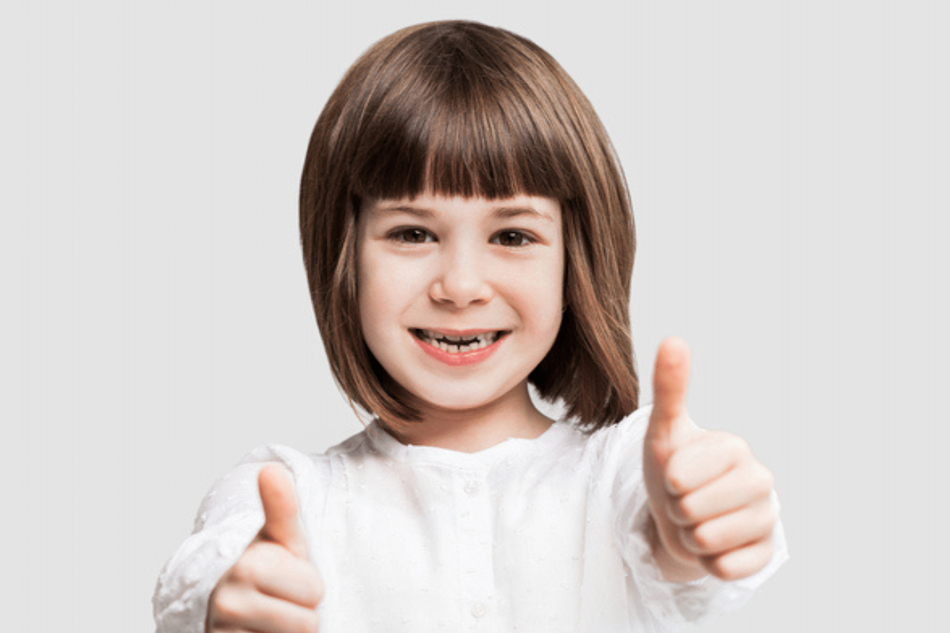 Young girl smiling and giving a thumbs up gesture